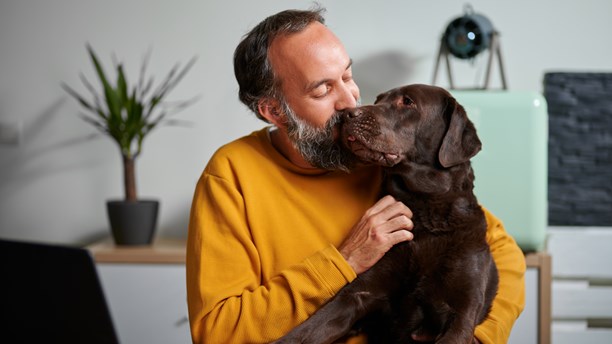 Mature man hugging his dog at home