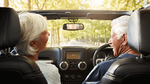 A man and woman enjoy a car drive together