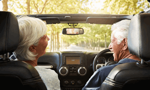 A man and woman enjoy a car drive together