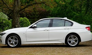 A four seater silver car parked outdoors.