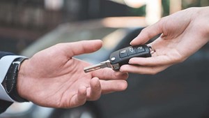 Car keys being handed from one person to another