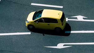 A yellow car turning at a junction.