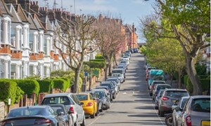 Residential street with cars parked along both sides of the road