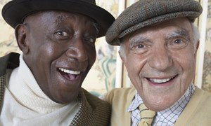 Two elderly male friends smiling for selfie together