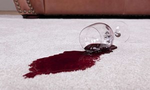 Spilled glass of red wine on a pale carpet