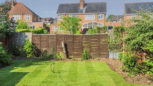 Garden with wooden fence panel at back and overlooking houses