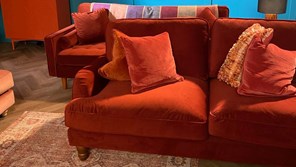 Two very similar orange sofas next to each other